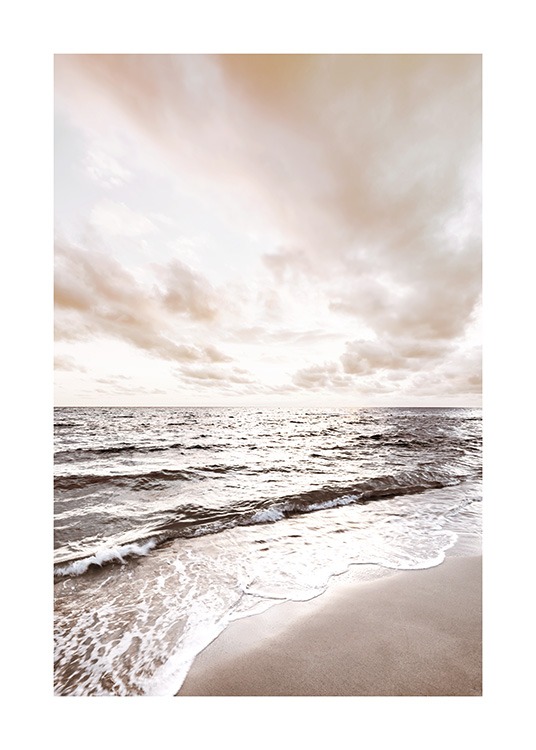  – Photograph of a calm ocean with a beach in the foreground and clouds in the background